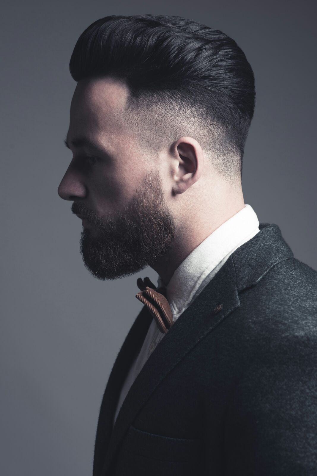 Signature slick-back with a tight skin fade and shaped beard